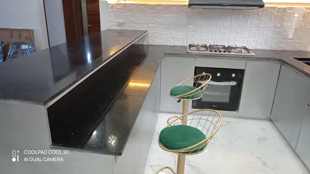 Finished kitchen interior with dark countertop and cabinets