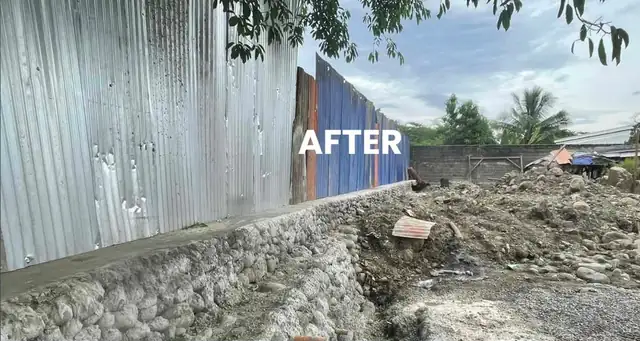 Completed riprap retaining wall along a property boundary